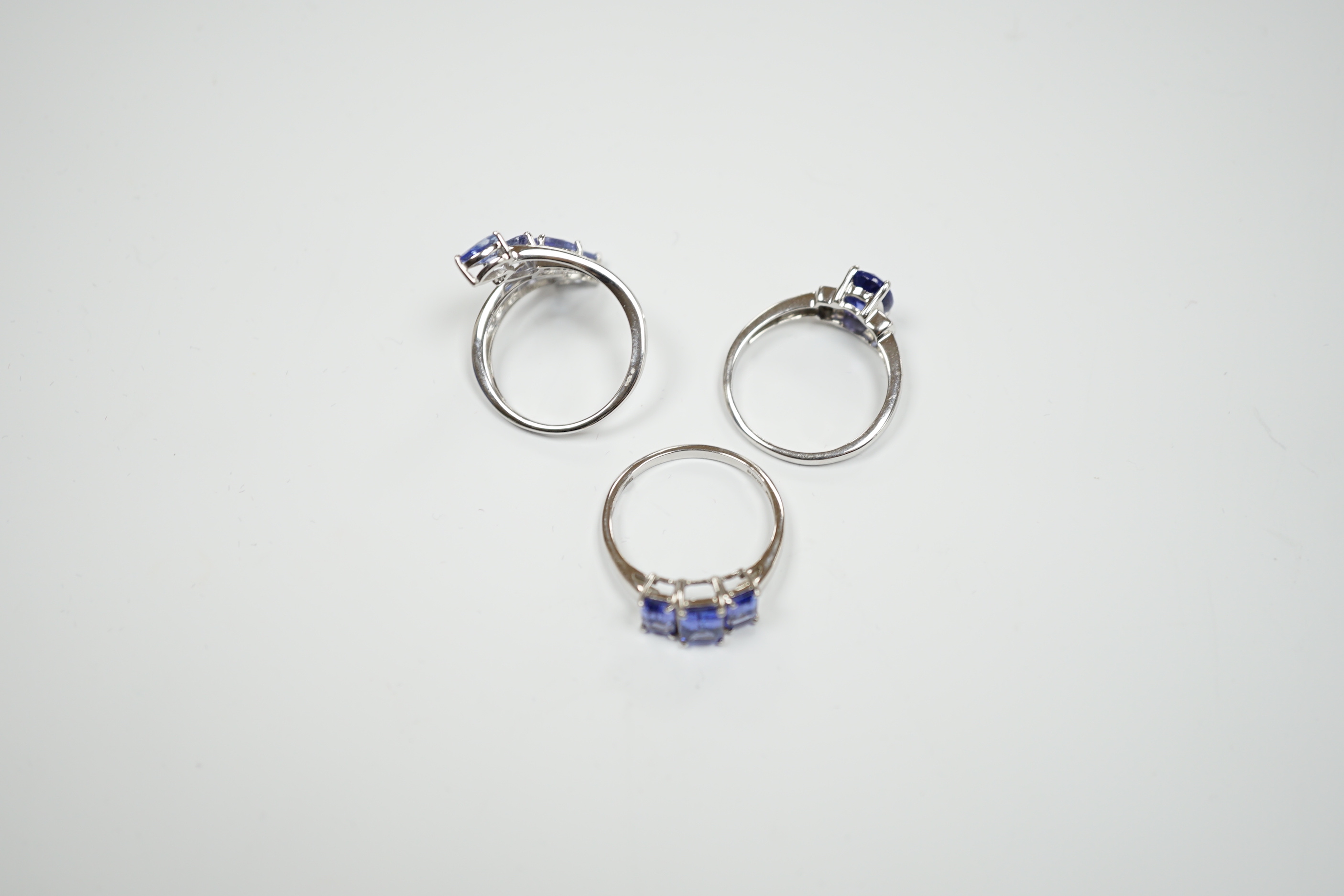 Three assorted modern 9ct white gold and tanzanite set dress rings, gross weight 8.4 grams.